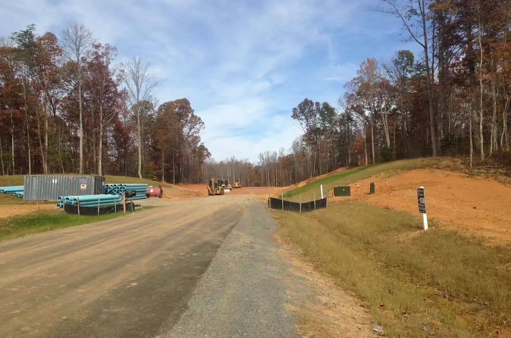 A road with trees and dirt on the side of it.