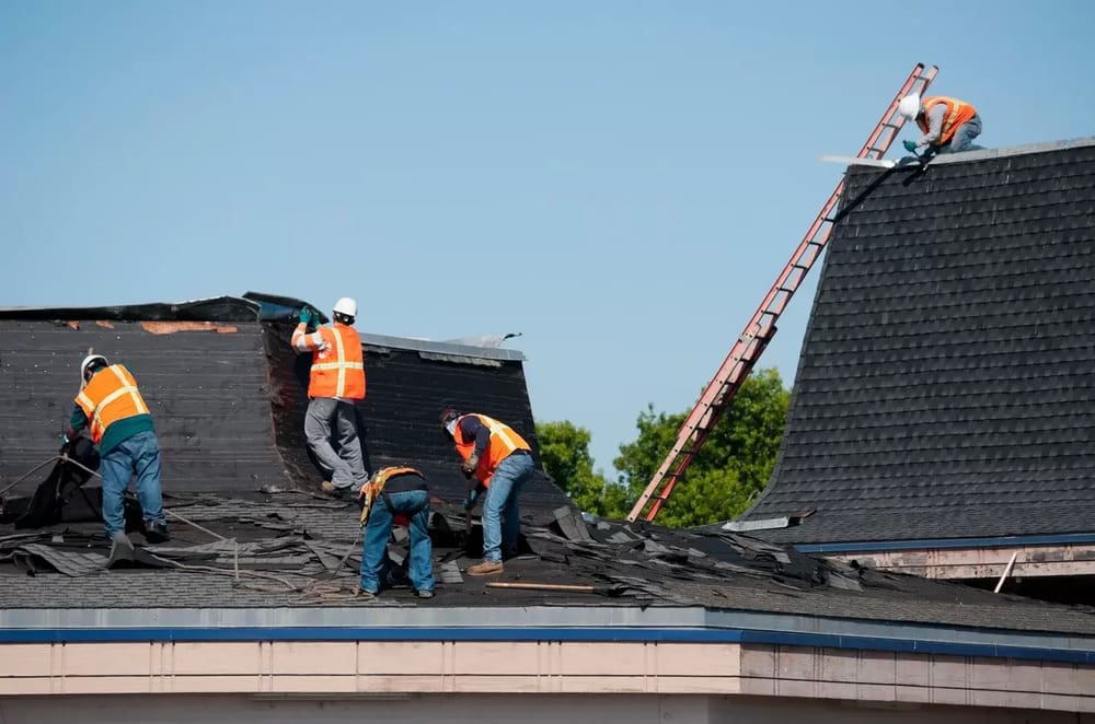 Three men working on a roof top.