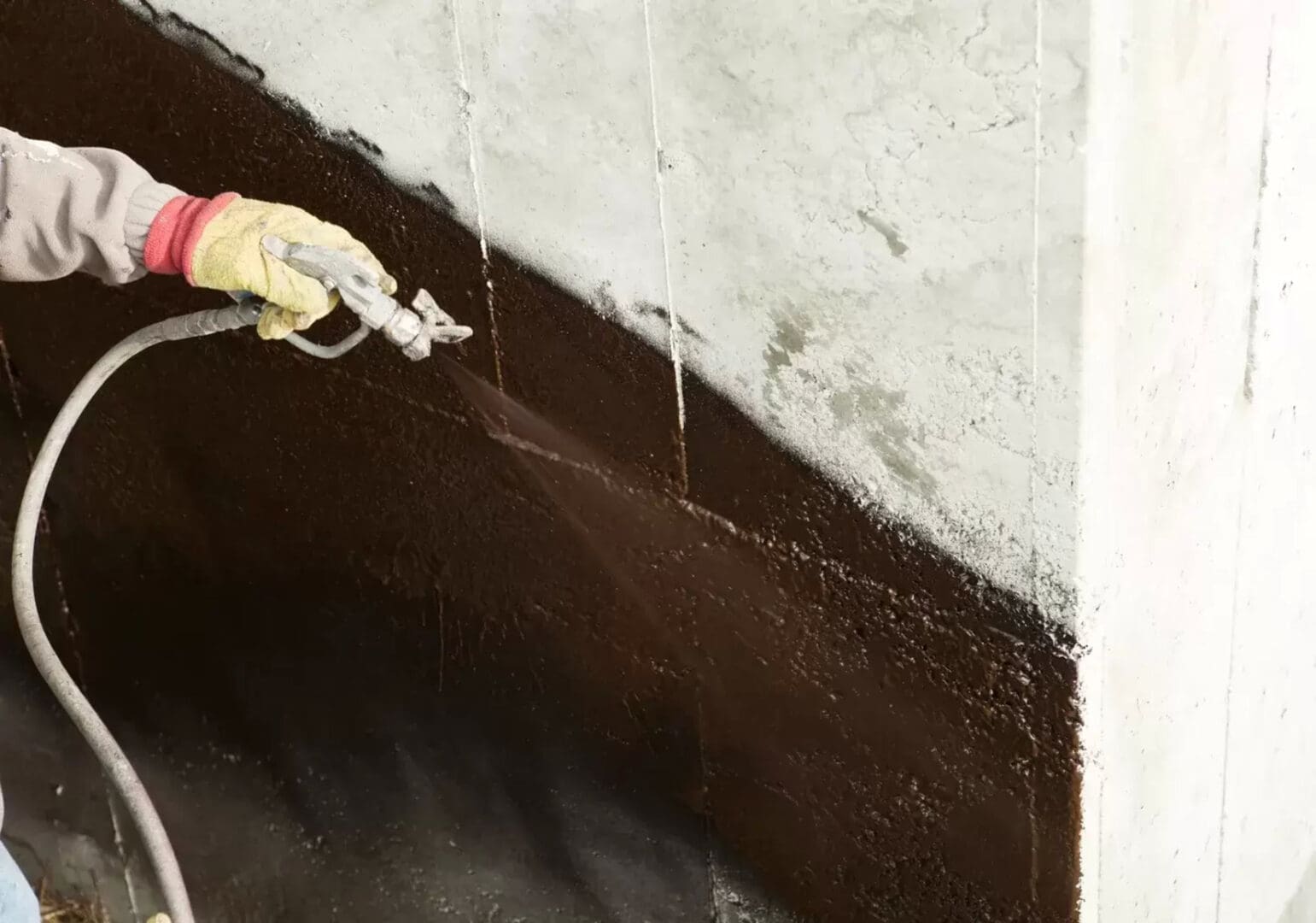 A person painting over the wall of a room.