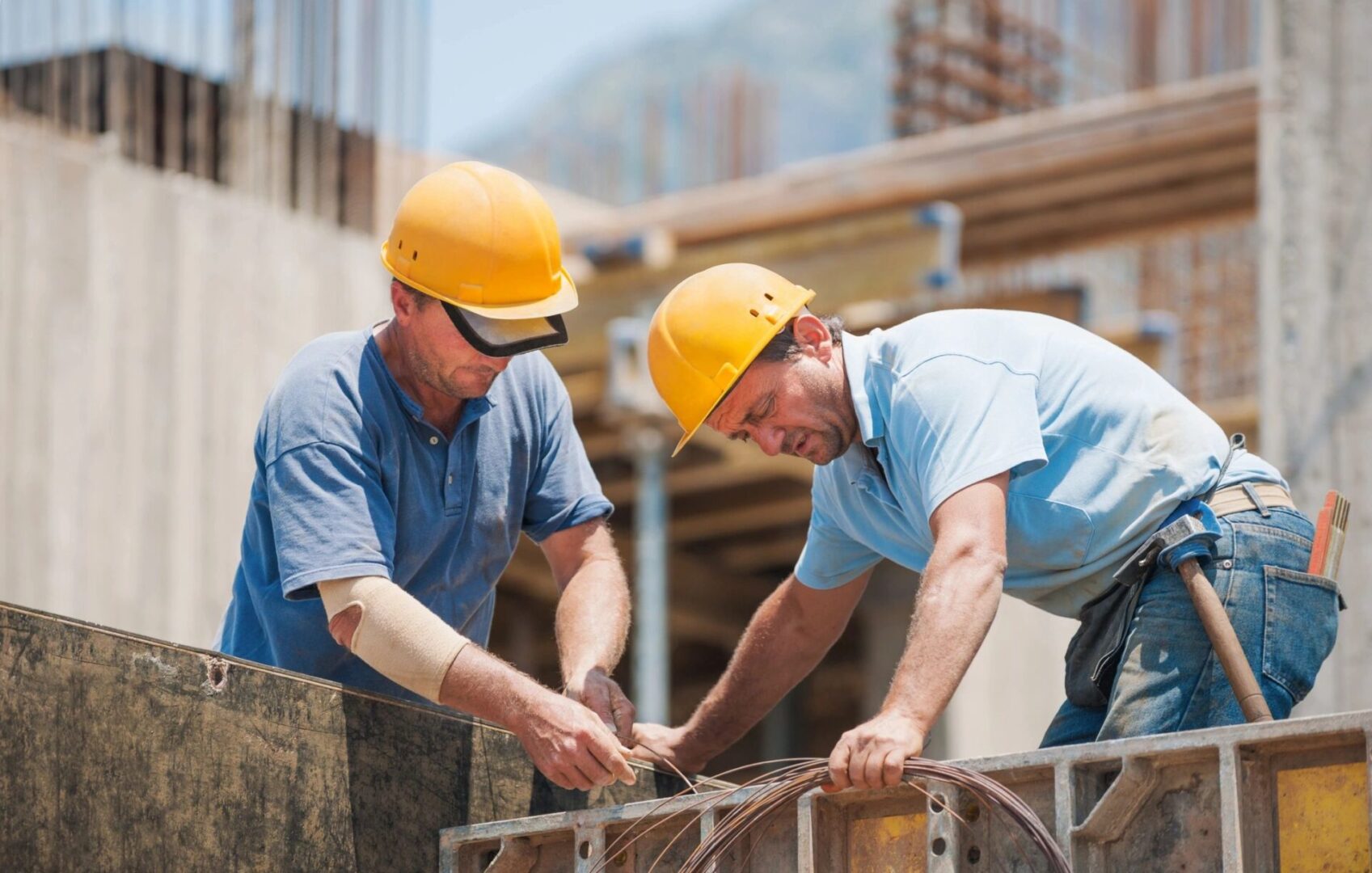 Two men in hard hats working on a building.