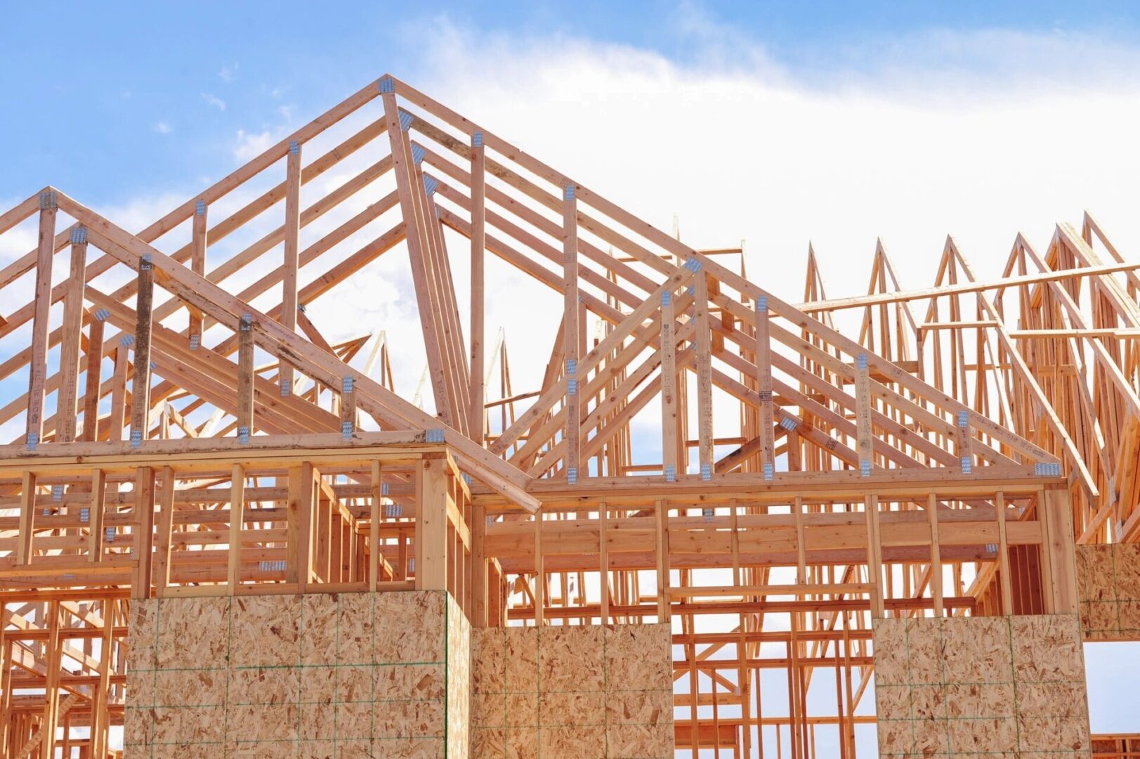 A building under construction with wooden beams and a sky background