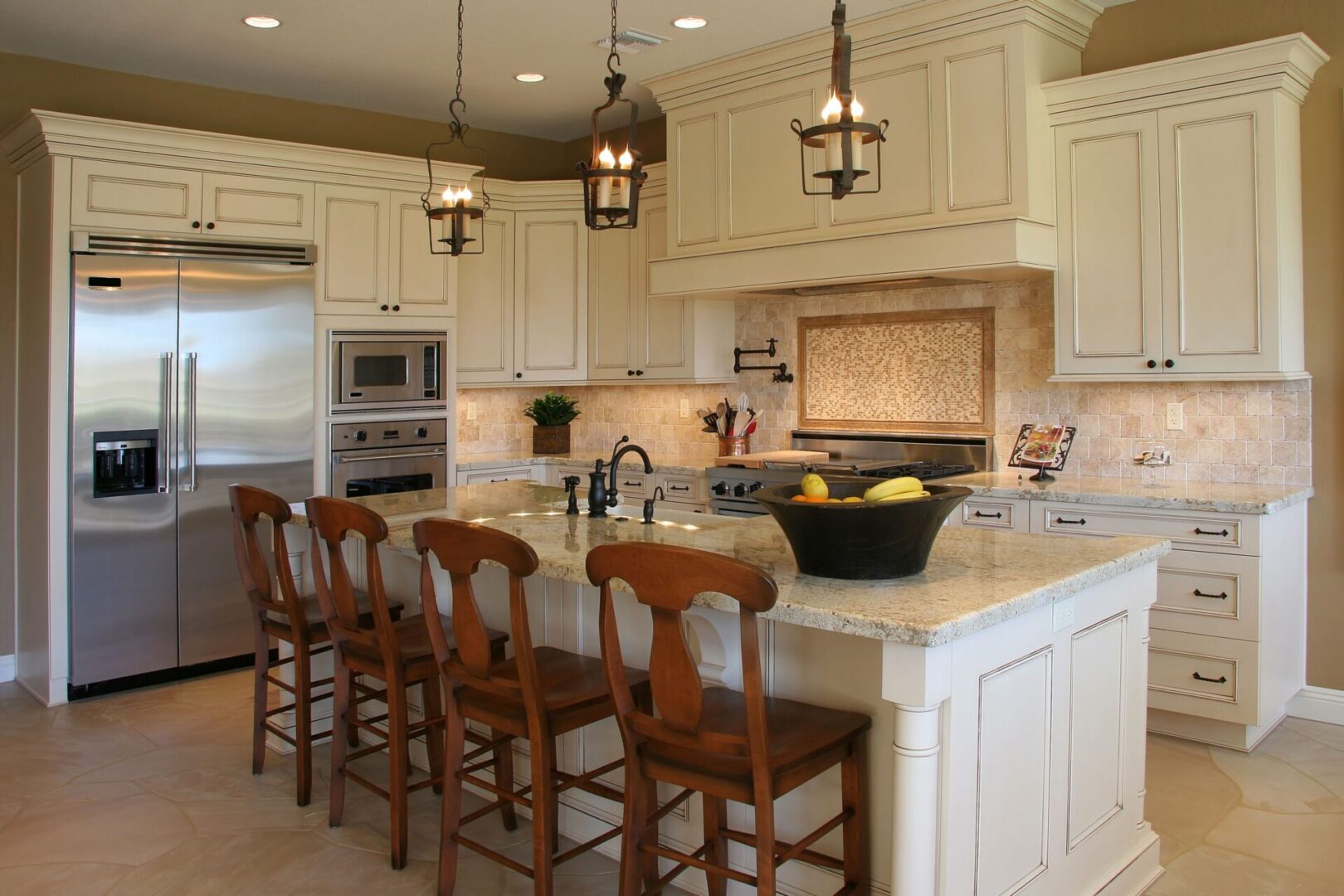 A kitchen with white cabinets and wooden chairs.