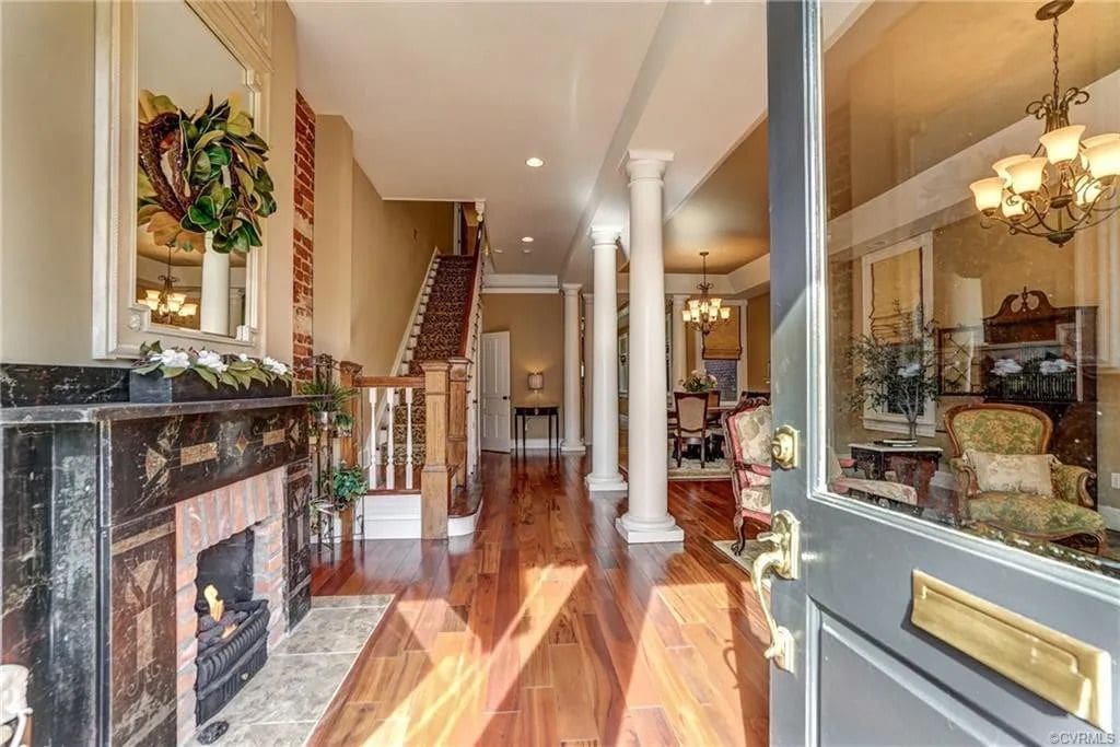 A large hallway with wooden floors and fireplace.